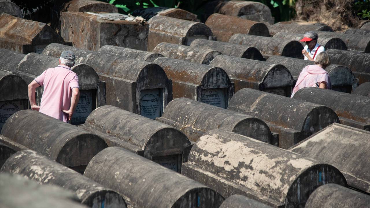 Besucher auf dem verwitterten jüdischen Friedhof in Yangon, Myanmar
